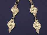 a close up of a pair of earrings on a blue surface