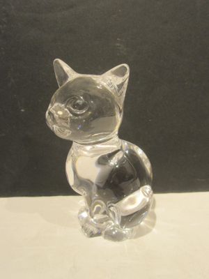 a glass figurine of a cat sitting on a table