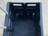 une boîte en plastique noire vide posée sur un sol en béton