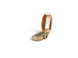 a small gold cell phone sitting on a white surface