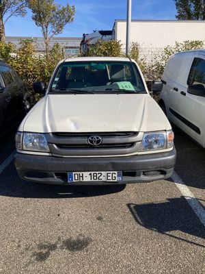 un camion blanc garé sur un parking à côté d'autres voitures