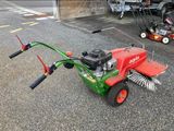 une tondeuse à gazon rouge et verte garée sur un parking