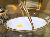 une table en verre sur laquelle est posée une assiette dorée