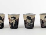 six verres à shot sur lesquels figurent les portraits d'un homme et d'une femme