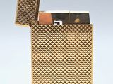 un briquet doré posé sur une surface blanche