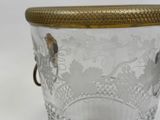 a glass container with a gold lid and a bird on it