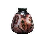 un vase orné d'un motif floral, posé sur un socle