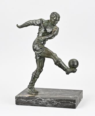 statue of a man kicking a soccer ball on a marble base