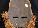 a close up of a wooden mask on a black background