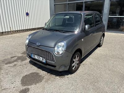 une photo d'une petite voiture garée devant un immeuble
