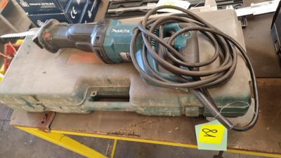 une perceuse posée sur une boîte à laquelle est attaché un cordon