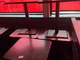 des tables et des bancs dans un restaurant, avec une lumière rouge qui filtre à travers la fenêtre