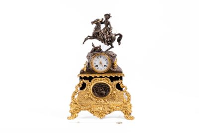 une horloge en or surmontée d'un cheval et d'un cavalier