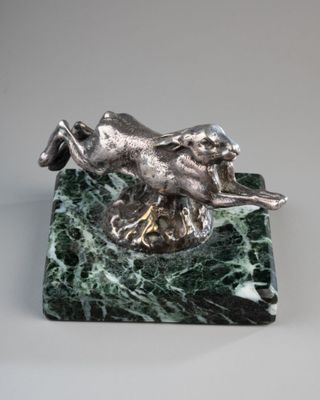 figurine de chien en marbre argenté et vert, posée sur un socle en marbre