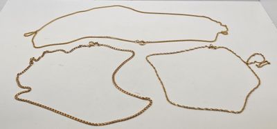 trois colliers en or posés sur une surface blanche, sur fond blanc