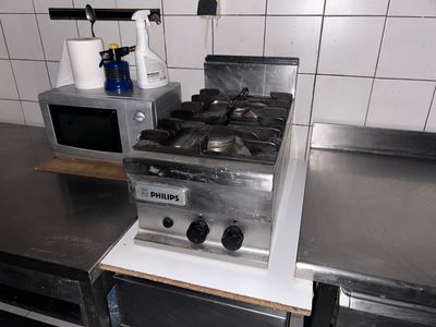 a stove and a microwave in a kitchen with stainless steel counter tops