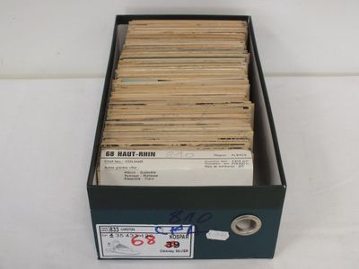 une boîte remplie de vieux disques posée sur une table blanche