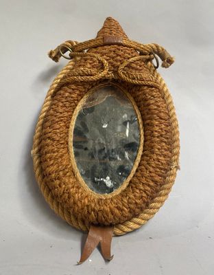 une corde enroulée autour d'un miroir accroché à un mur blanc