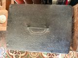 an old metal box with a handle on top of a table