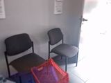two chairs and a table in a room with papers on the wall