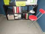 a small desk with two red chairs in front of a blue wall