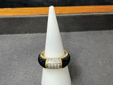 une bague noire et dorée avec un diamant serti au centre