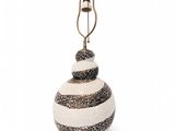 une boule de Noël en verre rayée de blanc et de noir, surmontée d'une clochette