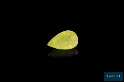 a yellow pear shaped diamond on a black surface