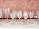 several empty wine glasses are lined up on a shelf