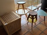three tables and two stools in the corner of a room