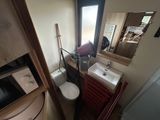 a small bathroom with a sink, toilet, and a microwave