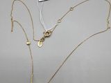 un collier de perles blanches et d'or sur fond blanc