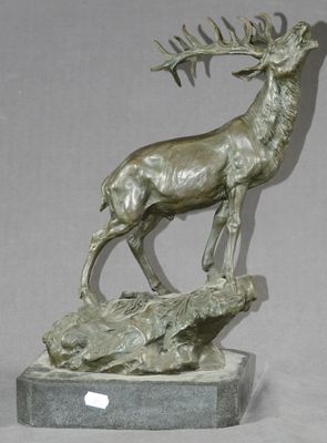 statue représentant un cerf perché sur un rocher, tenant une antilope dans la gueule