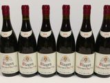 six bouteilles de vin rouge sont alignées sur une table