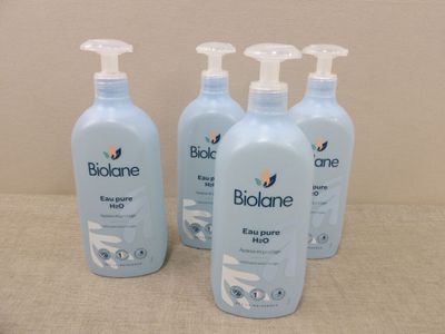 quatre flacons de lotion pour bébé Biolane posés sur une table