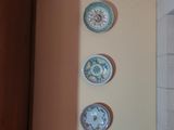 de nombreuses assiettes accrochées au mur au-dessus d'une chaise