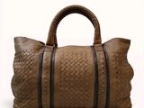the large brown handbag is made of woven leather and has two zippers