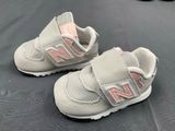 baby shoes with pink and white trims are on a black surface