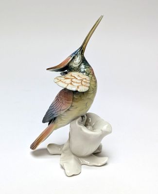 porcelain figurine of a bird perched on a white flower