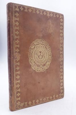 a brown leather book with a gold medallion on the cover