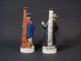 two figurines of a man and a woman standing next to each other