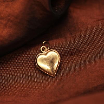 gold heart charm on a brown fabric