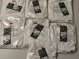 six paires de t-shirts blancs posées sur une table