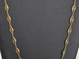 Collier plaqué or avec un motif torsadé, présenté sur un présentoir en forme de mannequin