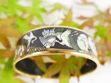 an image of a black and gold bangle with birds on it