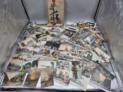 une valise remplie de vieilles cartes postales posée par terre