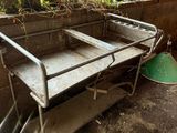 a metal table that is sitting in the dirt