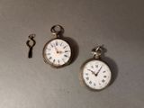 deux horloges et une clé posées sur une table