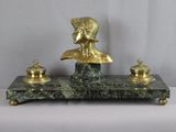 une statue représentant un homme assis sur un socle en marbre