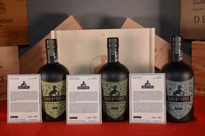 four bottles of wine are lined up on a red table
